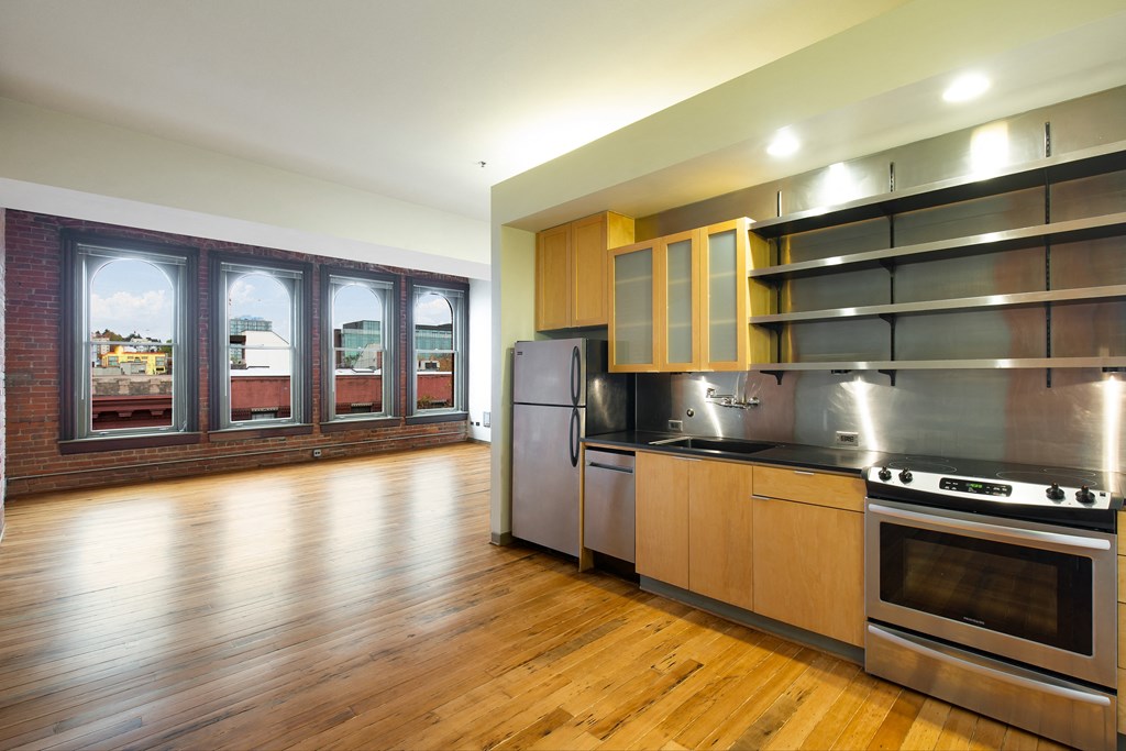 a kitchen with stainless steel appliances and a wood floor