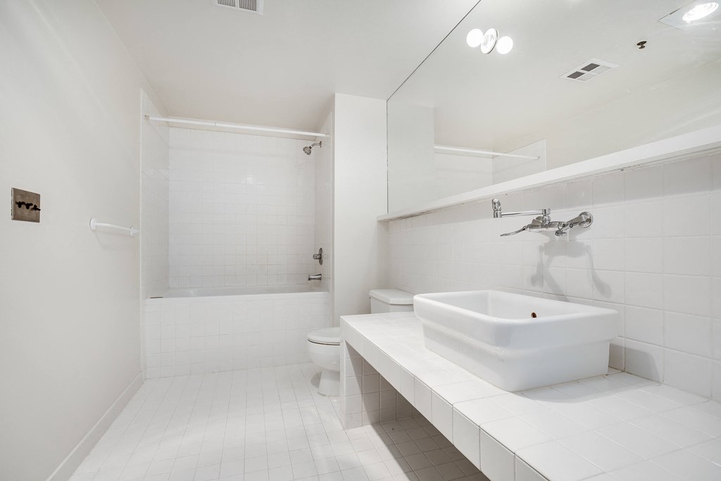 a white bathroom with a sink and a shower