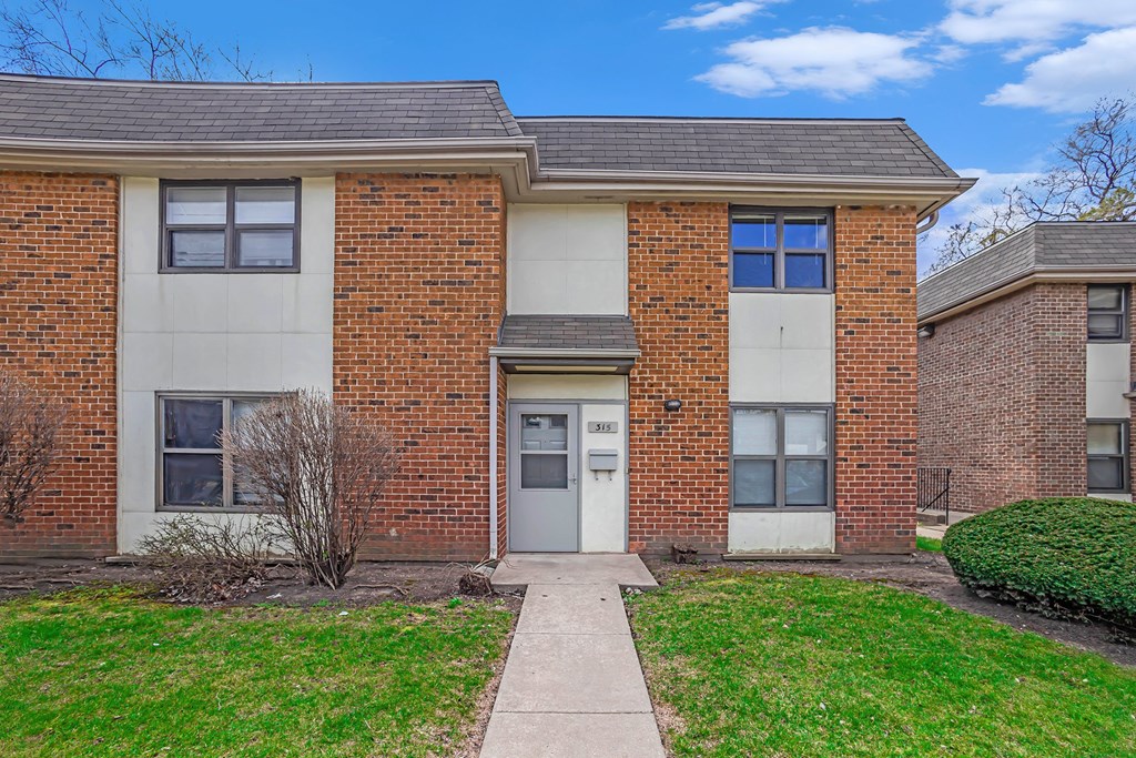 A brick building with a white door and windows.