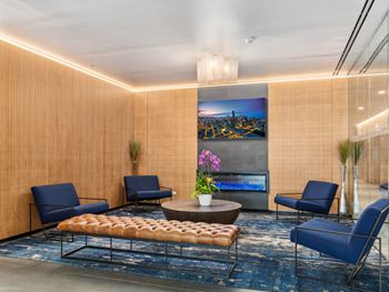 a lobby with blue chairs and a table and a painting on the wall at One 333, Chicago, Illinois, 60605