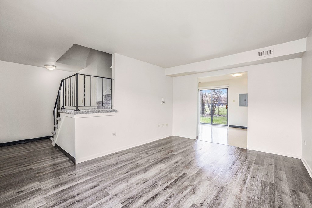 A spacious room with a staircase and a view of the outdoors.