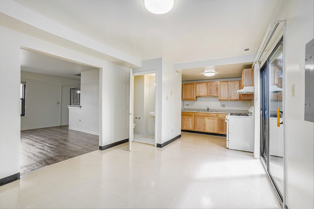 A kitchen area with a refrigerator, sink, and cabinets.
