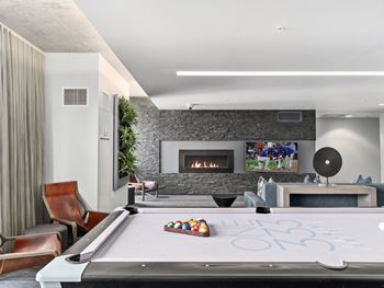 a living room with a pool table and a fireplace at One 333, Chicago, 60605