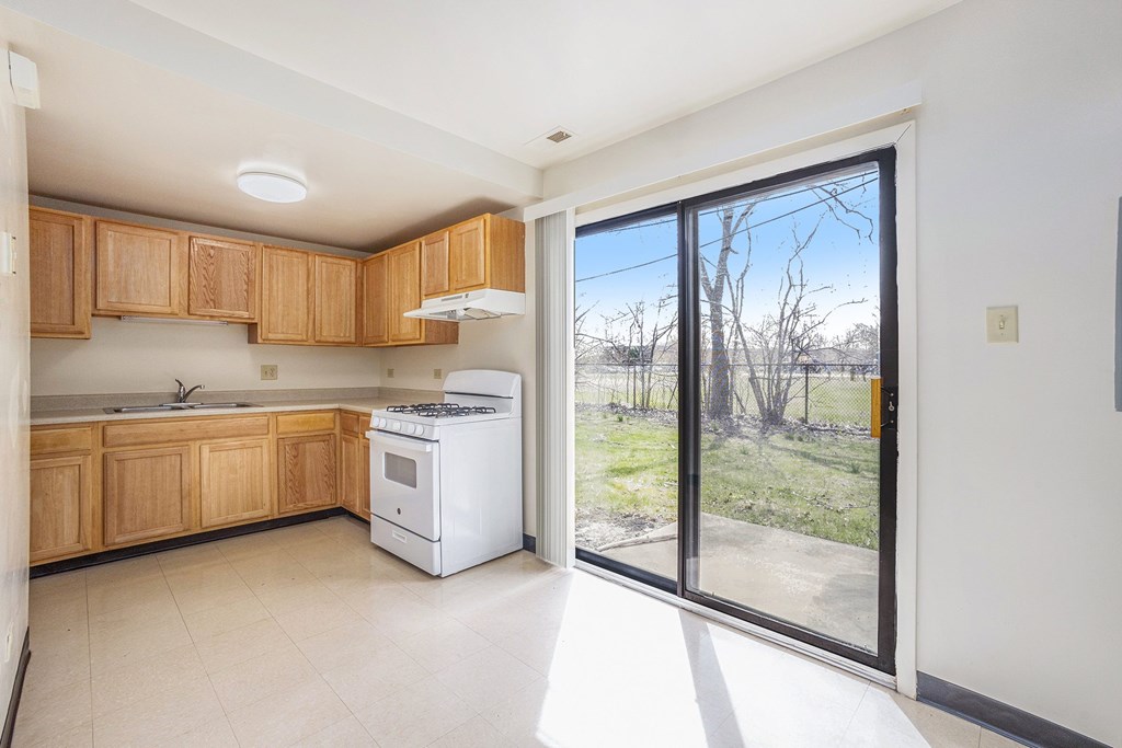 A kitchen with wooden cabinets and a white dishwasher.