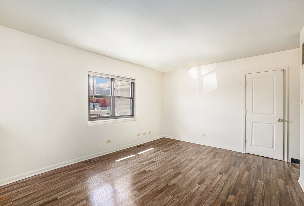 A room with a wooden floor and a window.