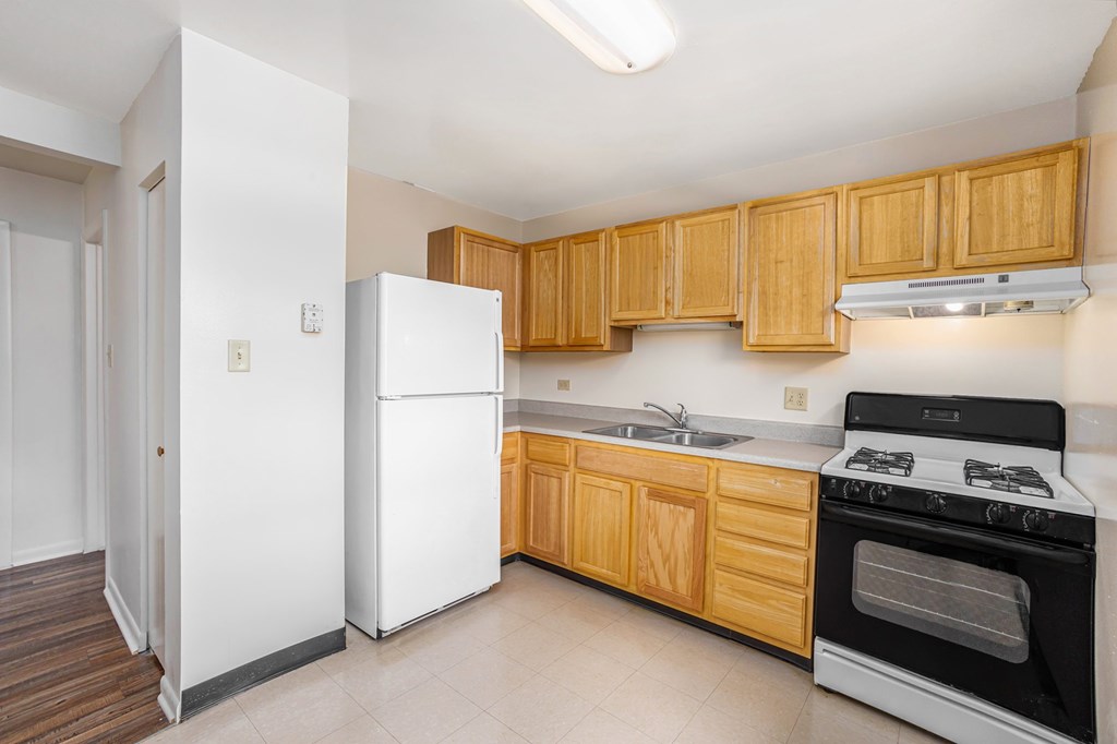 A kitchen with wooden cabinets and a white refrigerator.
