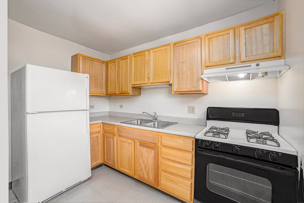 A kitchen with wooden cabinets and a white refrigerator.