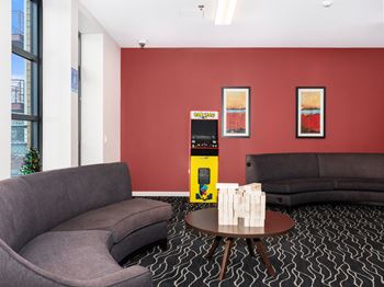 a living room with two couches and a coffee table with a vending machine