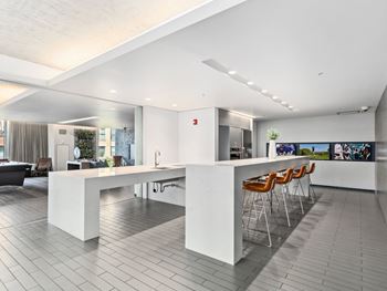 a large white kitchen with a bar and chairs at One 333, Chicago, 60605