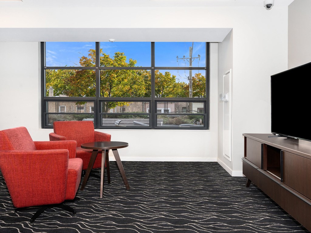 a living room with chairs and a television
