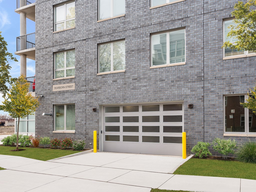 a gray brick building with a garage door on the side of it