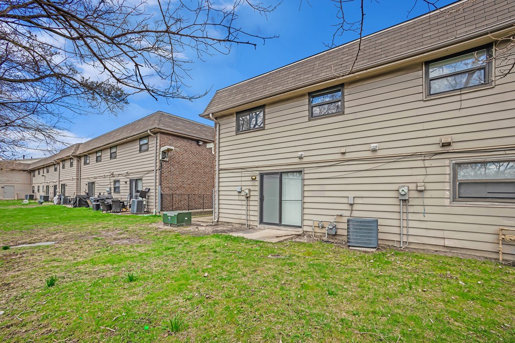 A row of houses with a green lawn in front.