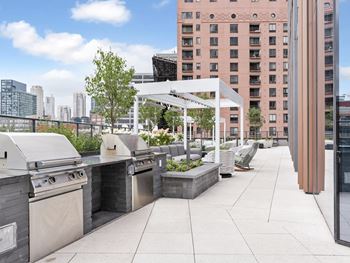 the outdoor patio of a building with barbecue grills and furniture  at Cassidy on Canal, Chicago, 60606