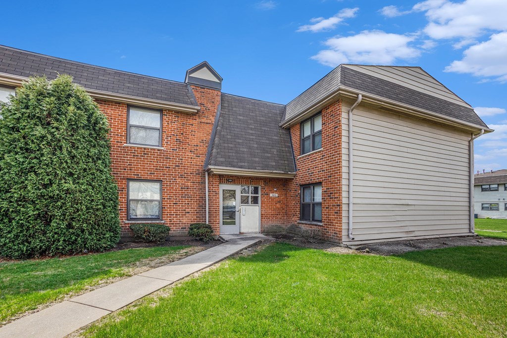A house with a brick facade and a grey garage door.