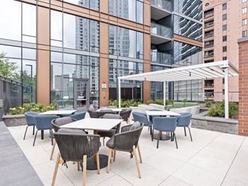 an outdoor patio with tables and chairs and tall buildings in the background  at Cassidy on Canal, Chicago, Illinois