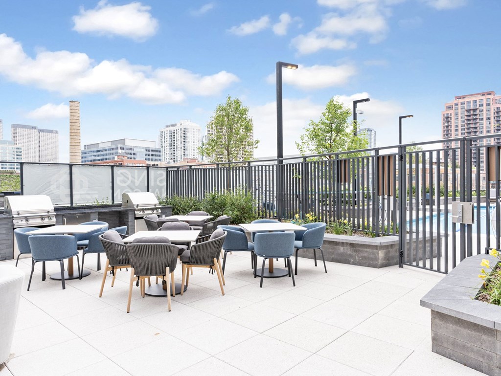 an outdoor patio with tables and chairs and a view of the city  at Cassidy on Canal, Chicago, IL