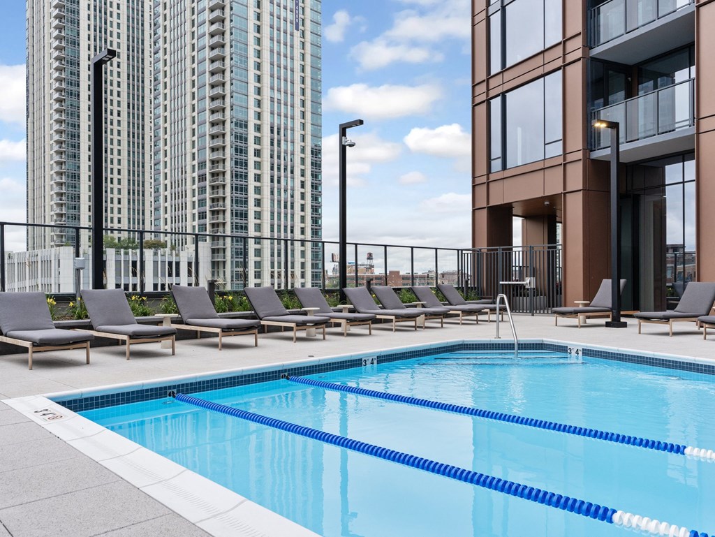 a swimming pool on the rooftop of a building with lounge chairs at Cassidy on Canal, Chicago, IL, 60654