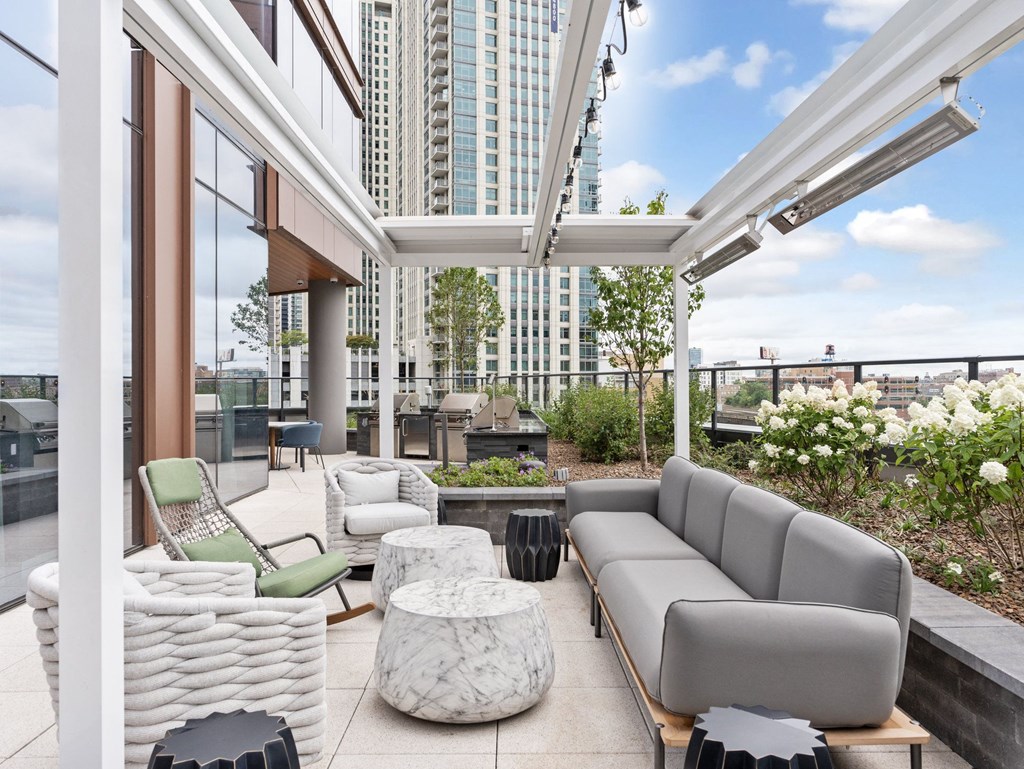 a living area with couches and chairs and a balcony with tall buildings at Cassidy on Canal, Chicago, IL, 60654