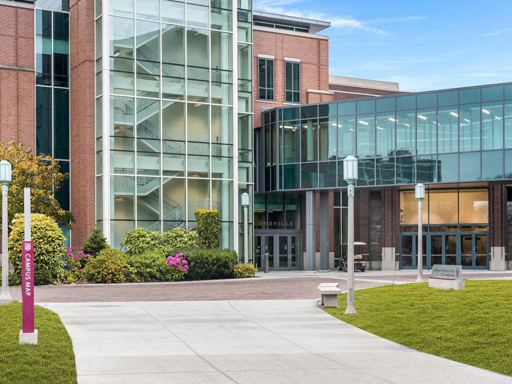 a sidewalk in front of a building with glass windows