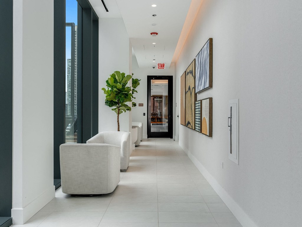 a long hallway with white walls and white chairs and a plant  at Cassidy on Canal, Chicago, Illinois