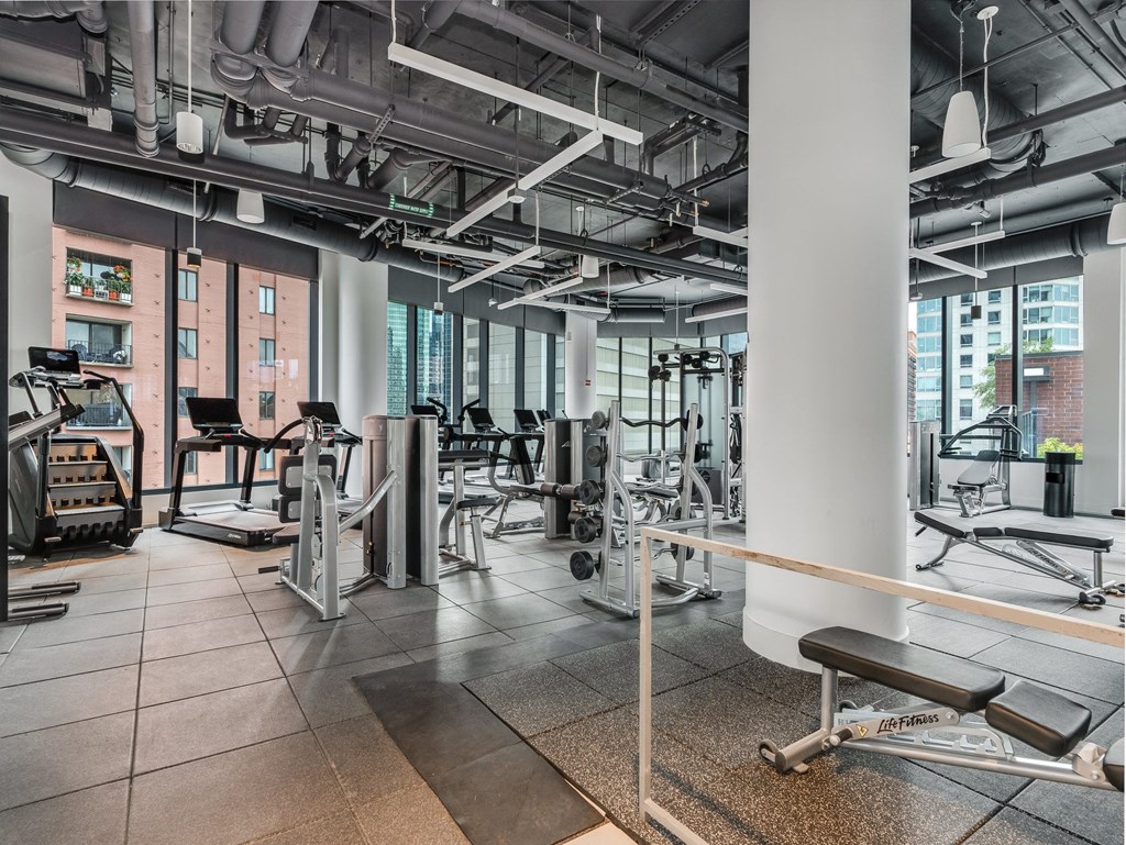 a gym with weights and cardio equipment in a building with tall windows  at Cassidy on Canal, Chicago, 60606