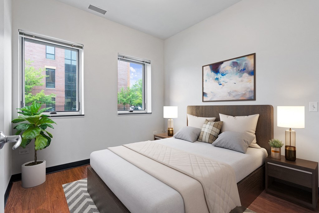 a bedroom with a large bed and two windows