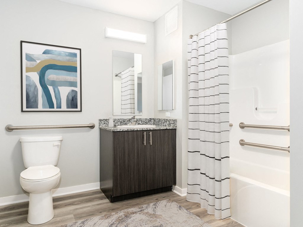 a bathroom with a toilet and a shower and a sink