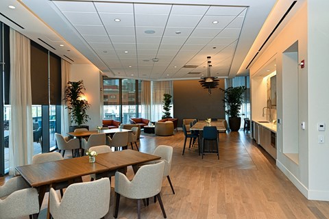 a large dining room with tables and chairs and a kitchen