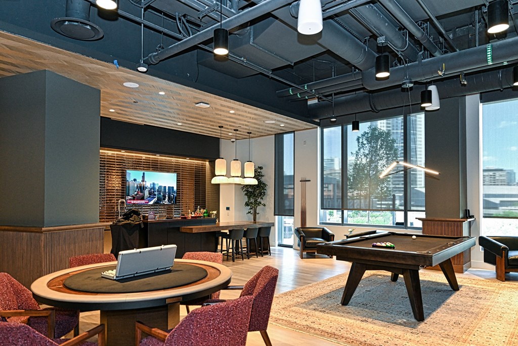 a lounge area with a pool table and a tv