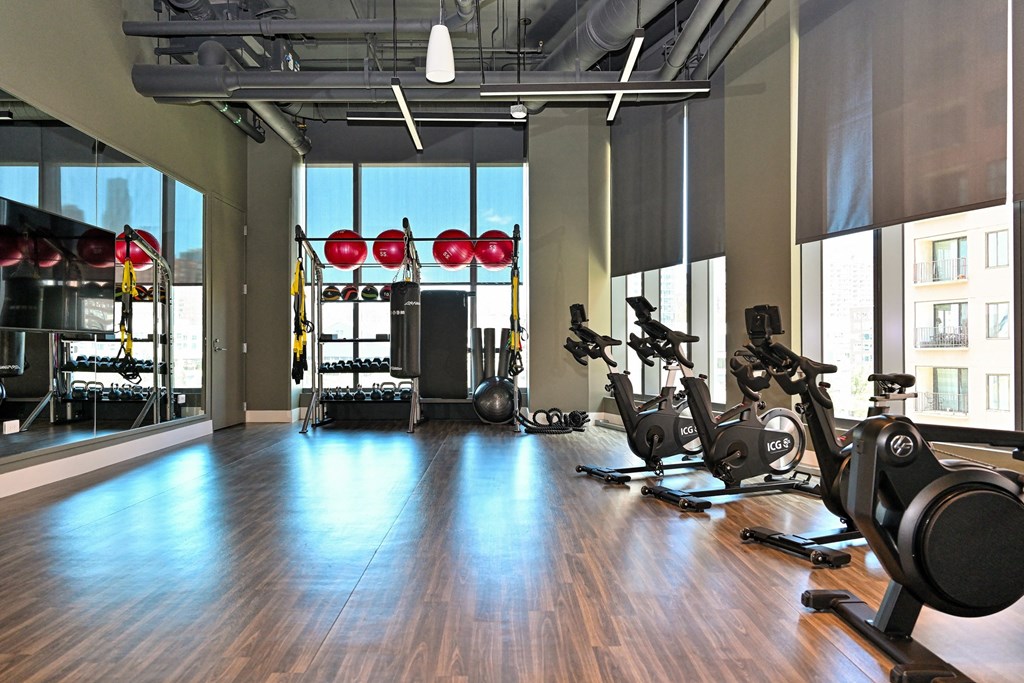 a workout room with weights and cardio machines in a gym