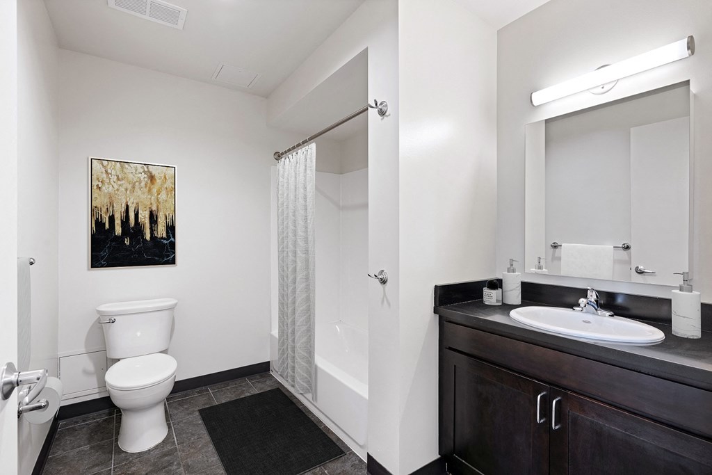 a bathroom with a toilet sink and shower and a mirror