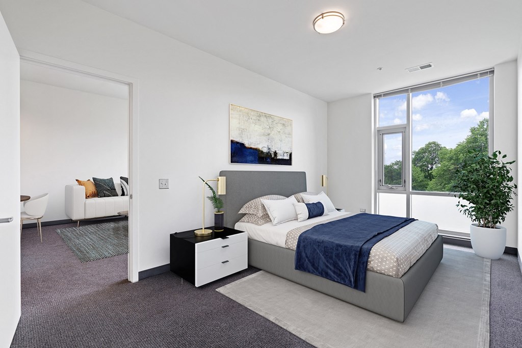 a bedroom with a bed and a large window