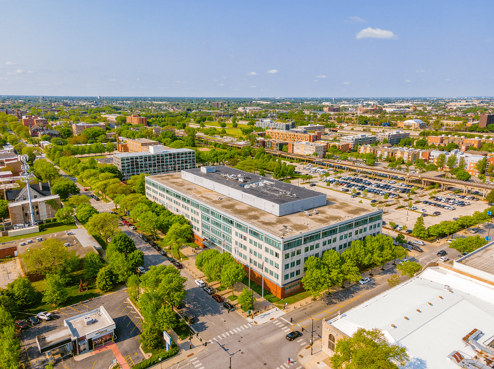 an aerial view of a large building with a parking lot in front of it