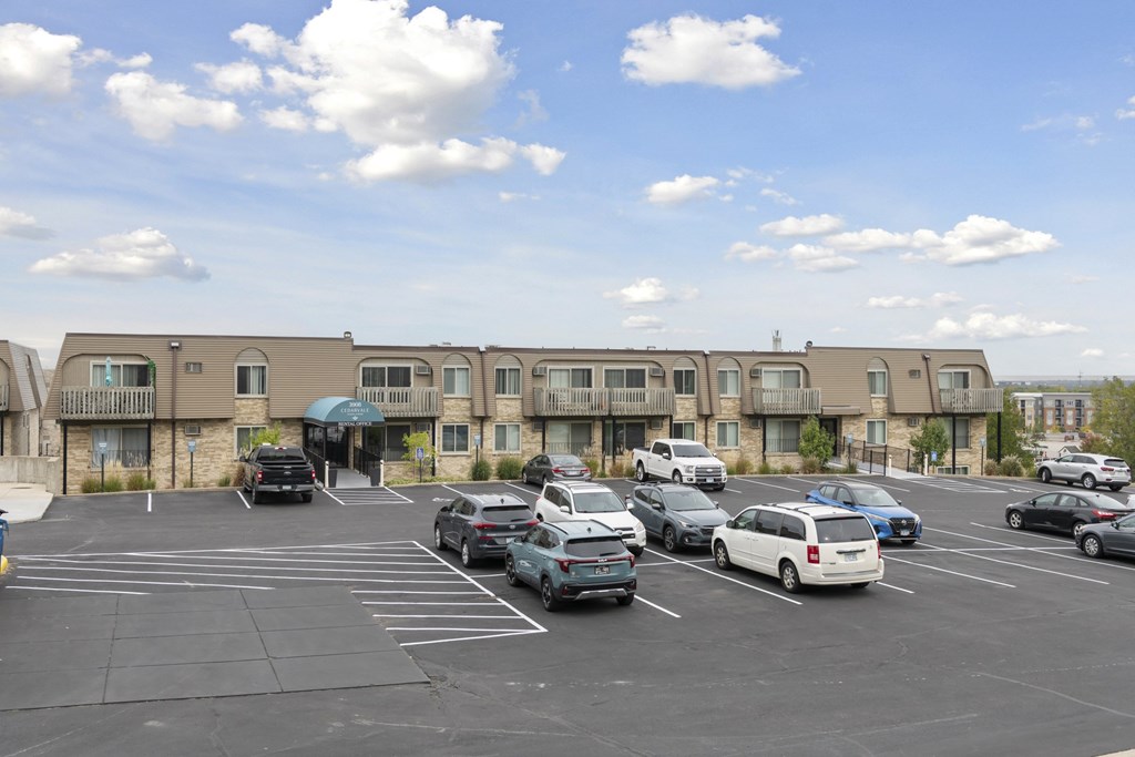 A parking lot with cars and a building in the background.