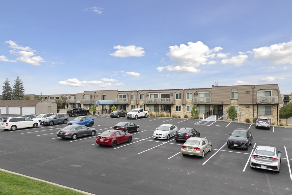 A parking lot with cars and a building in the background.
