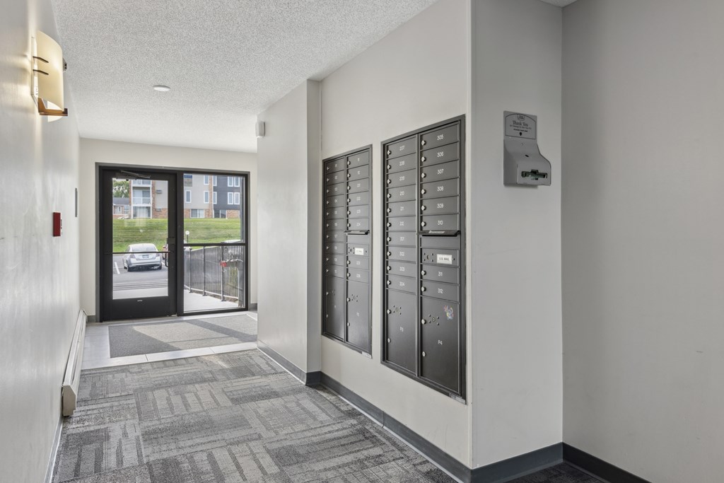 A hallway with a black door and a wall of vending machines.