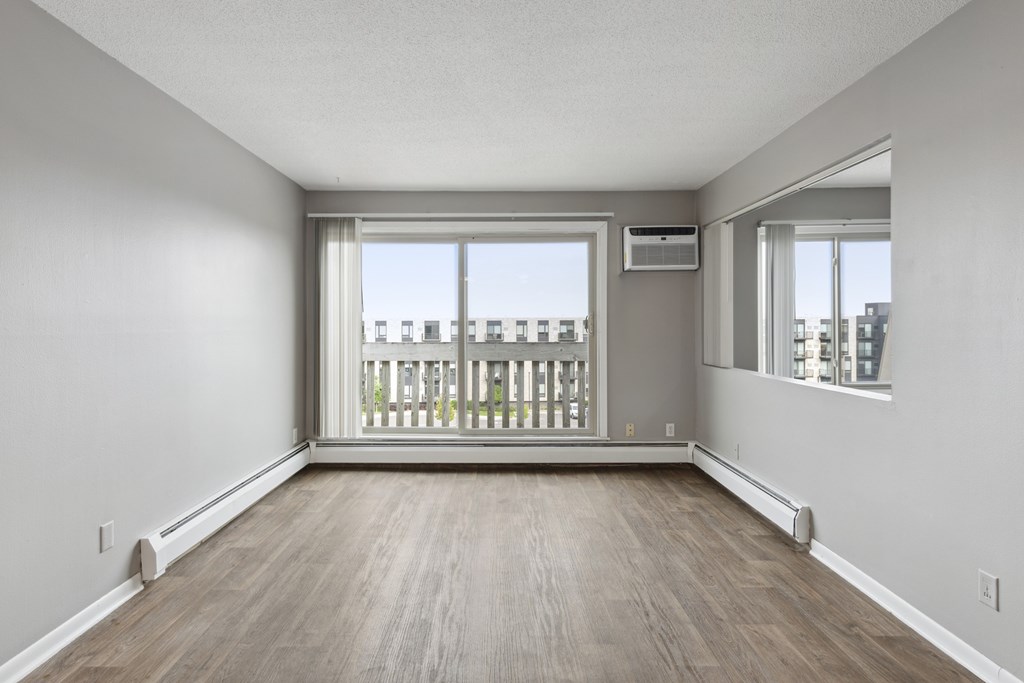 A spacious room with a balcony overlooking a cityscape.