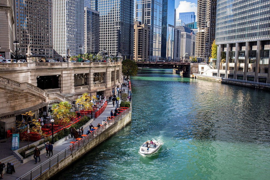 a boat is going down a river in a city at Columbus Plaza, Illinois, 60601