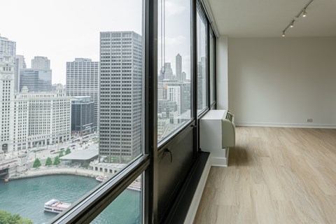 A room with a large window overlooking a river and city buildings at Columbus Plaza, Chicago, Illinois
