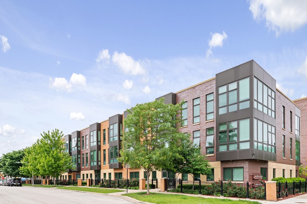an exterior view of a building with green grass and trees
