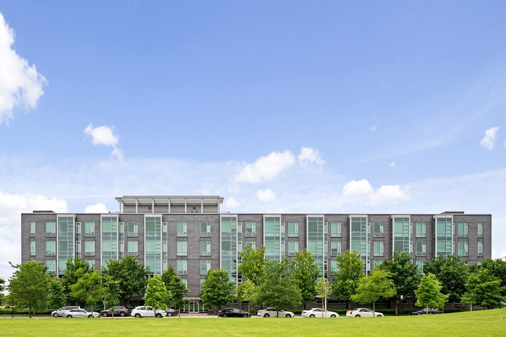 a large apartment building with cars parked in front of it