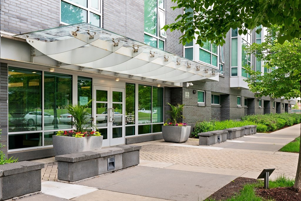 the front entrance of a building with glass doors and awning