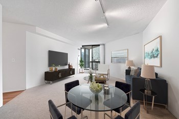 Dining room and view of kitchen in Asbury Plaza River North apartments. - Photo Gallery 5