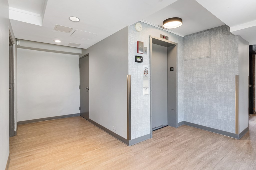 elevators with a wood floor and grey walls at Eden Commons, Chicago, Illinois