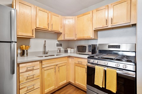 a kitchen with wooden cabinets and stainless steel appliances