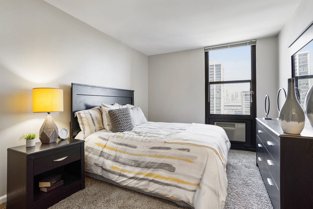 a bedroom with a large bed and a large window at Eden Commons, Illinois, 60616