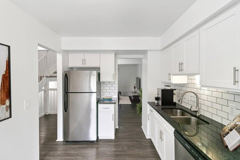 a kitchen with white cabinets and a stainless steel refrigerator