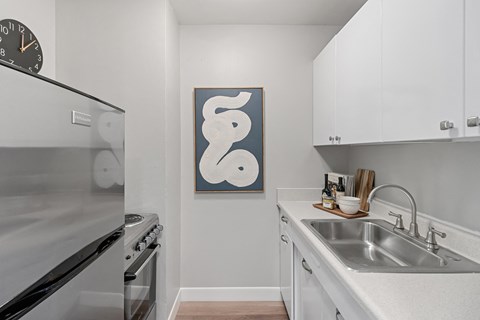 an apartment kitchen with stainless steel appliances and a sink