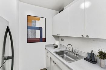 a kitchen with white cabinetry and a sink