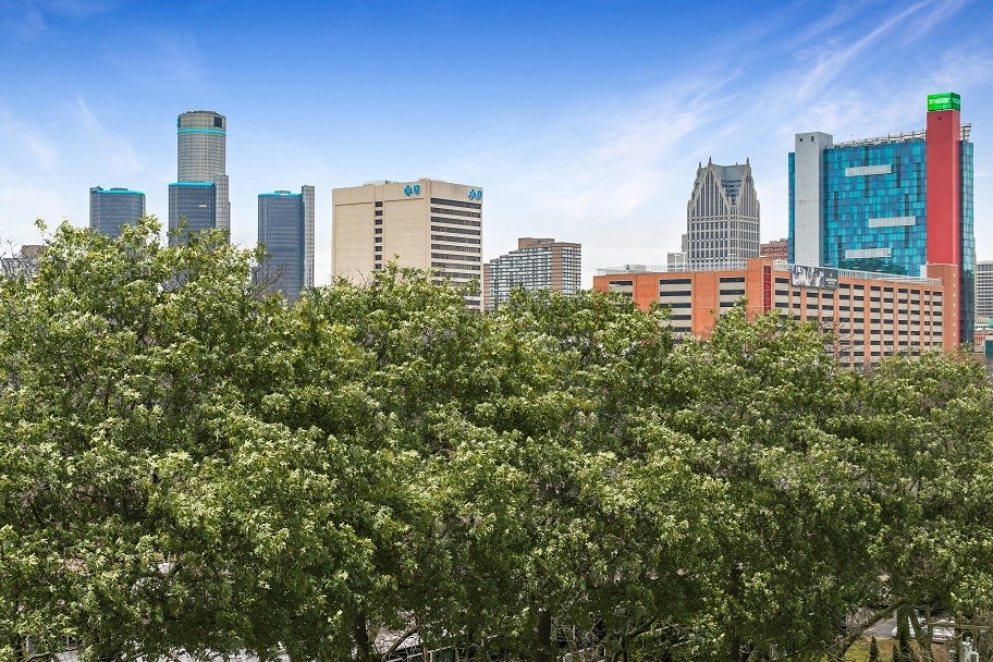 a city skyline with trees in the foreground at The Pavilion, Detroit, MI, 48207